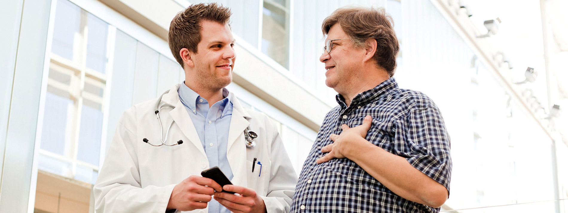 A male doctor smiling and talking with a patient.