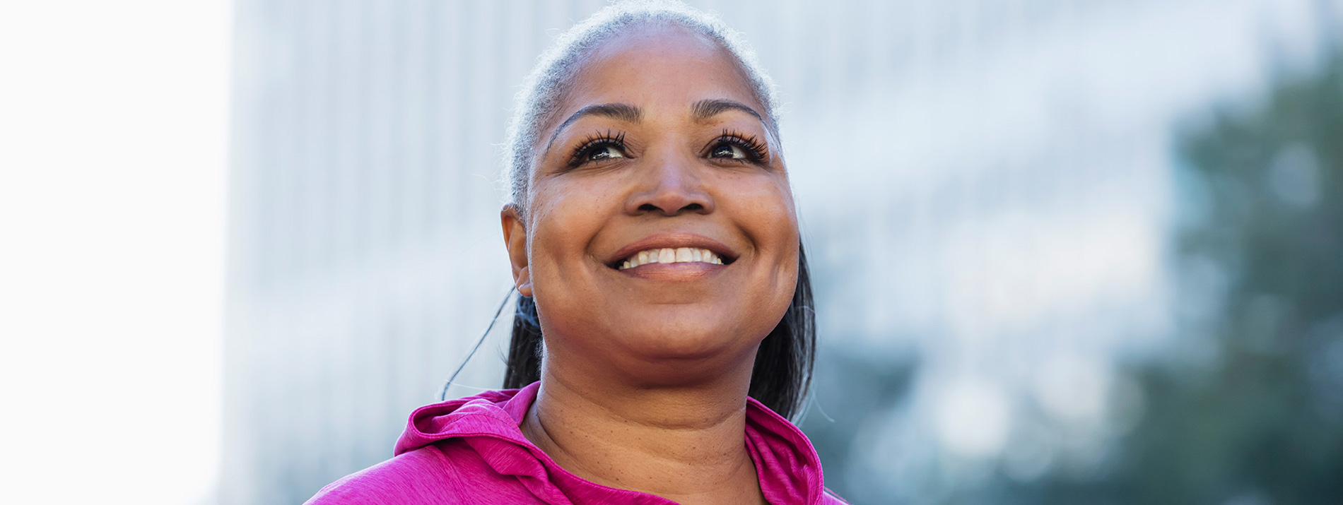 A centered portrait of a woman wearing a pink sweater.