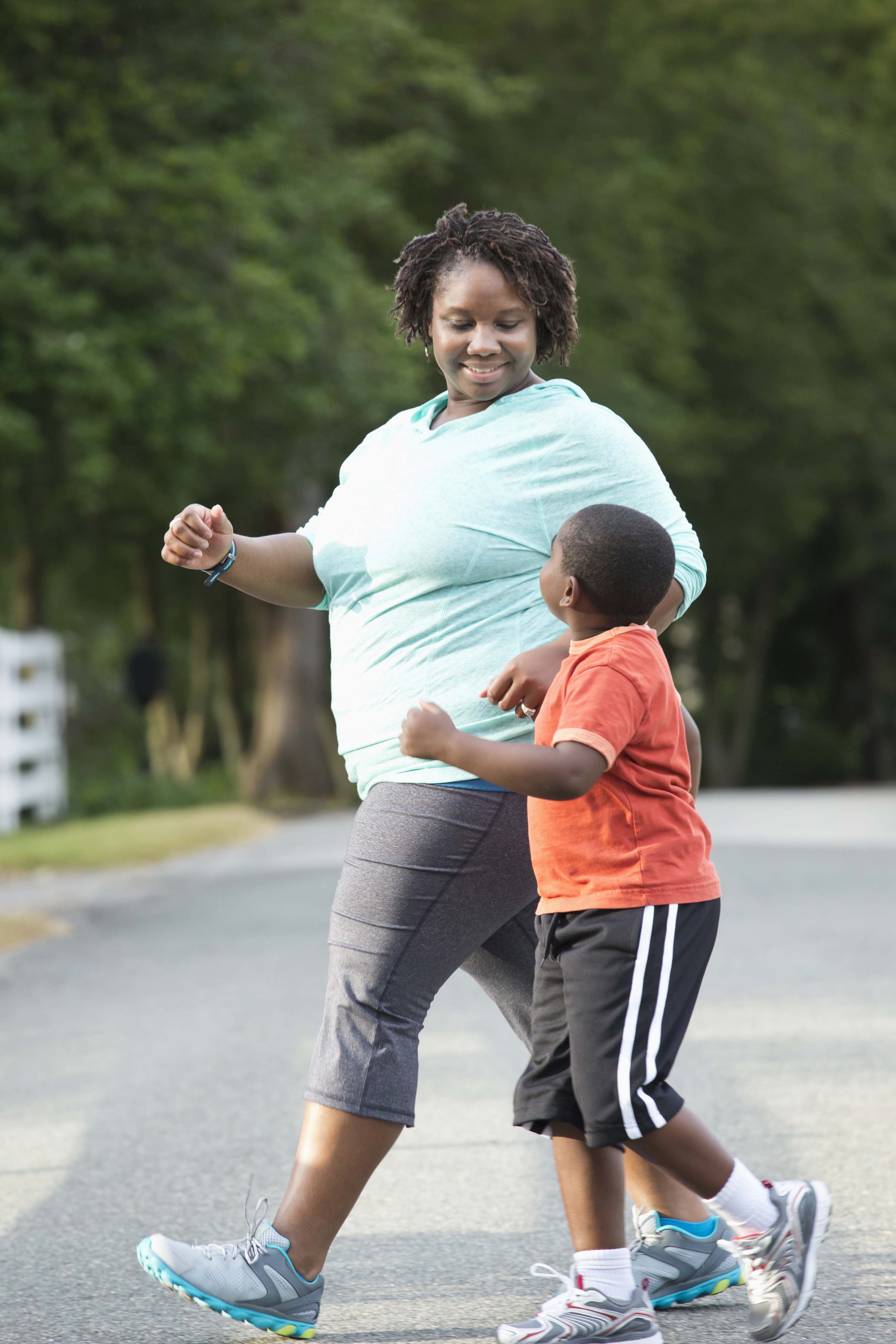 Black mother and son walking on road