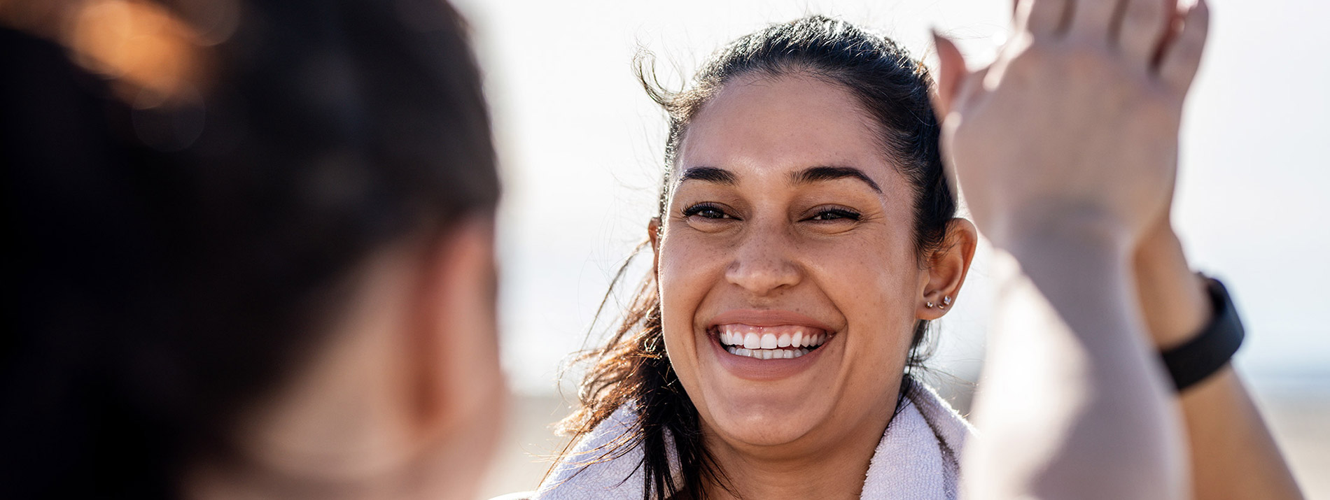 Two women facing and high-fiving eachother with a big smile.